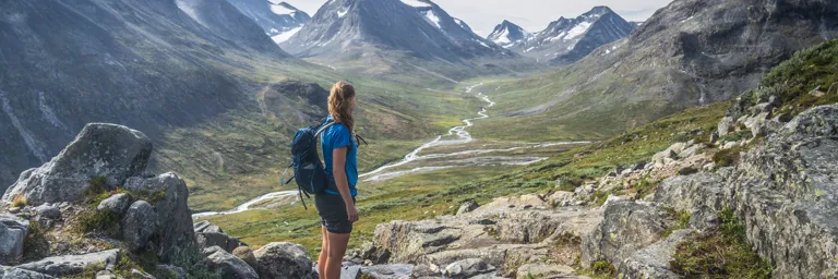 Woman Walking In Mountains Wearing Backpack 768px